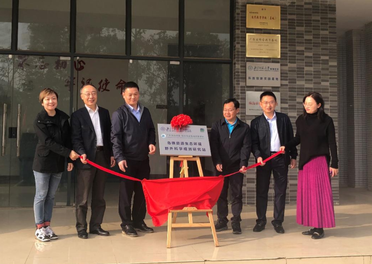 A group of people standing in front of a building

Description automatically generated with low confidence